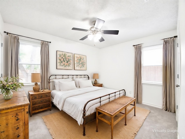 bedroom featuring light colored carpet and a ceiling fan
