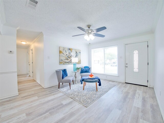 sitting room featuring ornamental molding, wood finished floors, a textured ceiling, a ceiling fan, and baseboards