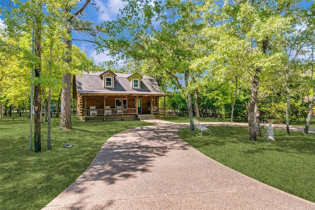 7386 Clint Ct, Athens, TX 75752 - log cabin with covered porch, log siding, driveway, and a front lawn