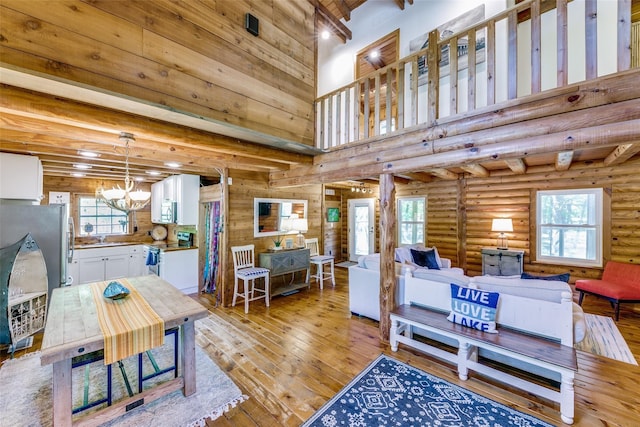 7386 Clint Ct, Athens, TX 75752 - living room with a chandelier, light wood-style floors, healthy amount of natural light, beamed ceiling, and a towering ceiling