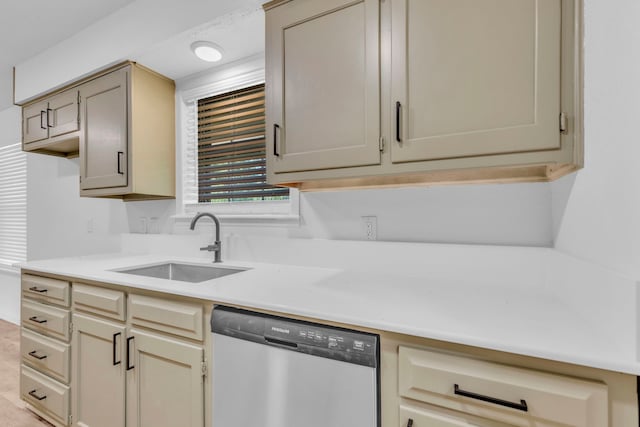 kitchen with stainless steel dishwasher, a sink, and light countertops
