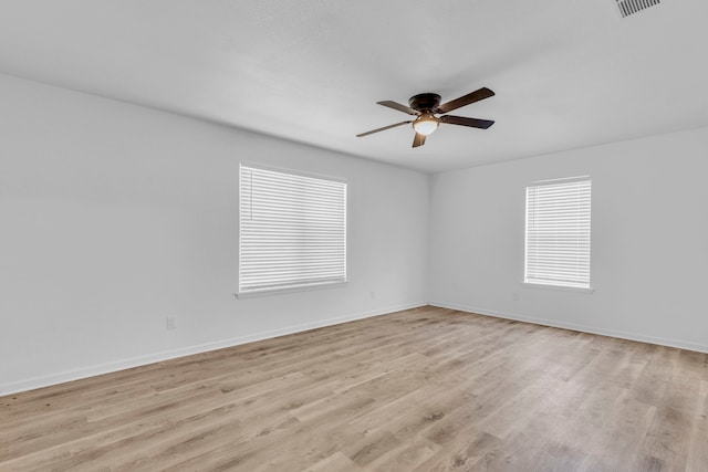 unfurnished room featuring a ceiling fan, light wood finished floors, and baseboards