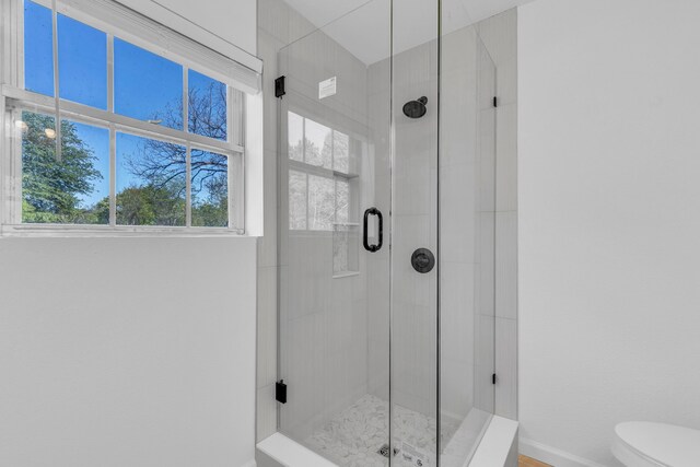 bathroom with a shower stall, baseboards, and toilet