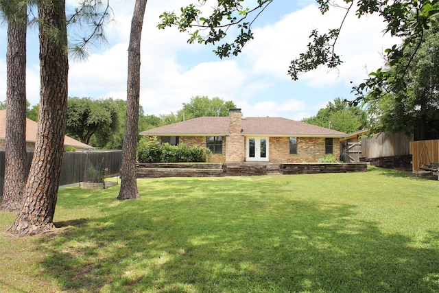 view of front of house featuring french doors, brick siding, and a chimney