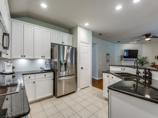 kitchen featuring stainless steel fridge, a sink, a ceiling fan, white cabinetry, and backsplash