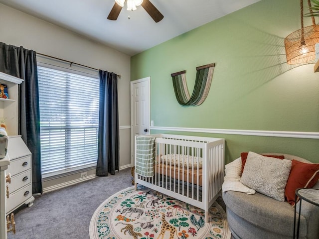 carpeted bedroom featuring multiple windows, a ceiling fan, and baseboards