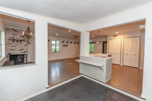 2850 Claudette Ave, Dallas, TX 75211 - kitchen featuring a fireplace, hanging light fixtures, open floor plan, light countertops, and crown molding