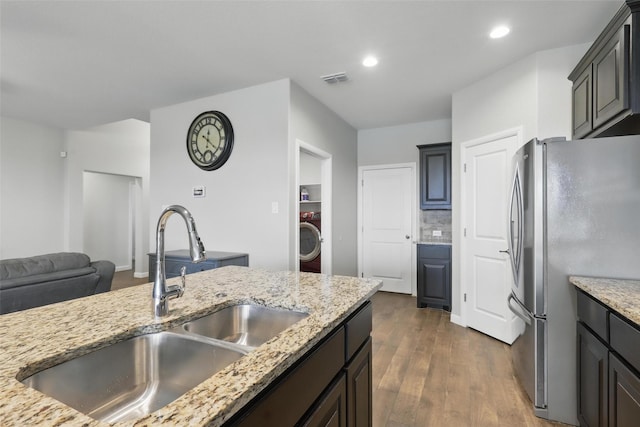 1206 Burlingame Dr, Cleburne, TX 76033 - kitchen featuring freestanding refrigerator, washer / clothes dryer, a sink, open floor plan, and light stone counters