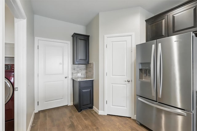 1206 Burlingame Dr, Cleburne, TX 76033 - kitchen with stainless steel fridge with ice dispenser, dark wood-style flooring, tasteful backsplash, light stone counters, and washer / clothes dryer