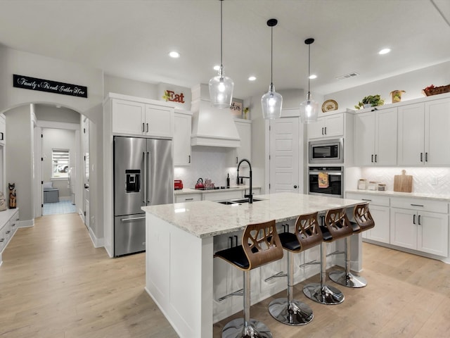 650 Winkler Way, Springtown, TX 76082 - kitchen with appliances with stainless steel finishes, a sink, decorative backsplash, light wood-style floors, and white cabinets