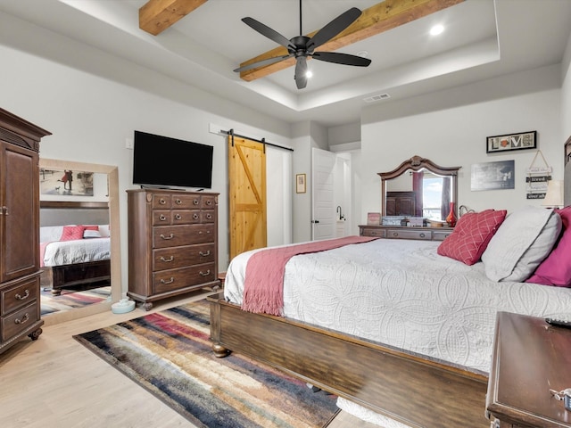 650 Winkler Way, Springtown, TX 76082 - bedroom featuring a barn door, light wood finished floors, a tray ceiling, beamed ceiling, and ceiling fan