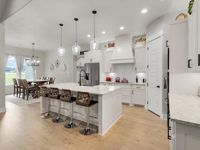 650 Winkler Way, Springtown, TX 76082 - kitchen with premium range hood, high end fridge, light wood-style flooring, black electric stovetop, and recessed lighting