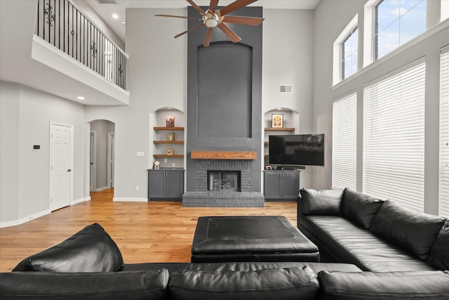 5610 Kensington Ct, Parker, TX 75002 - living room with a high ceiling, ceiling fan, arched walkways, baseboards, and a fireplace