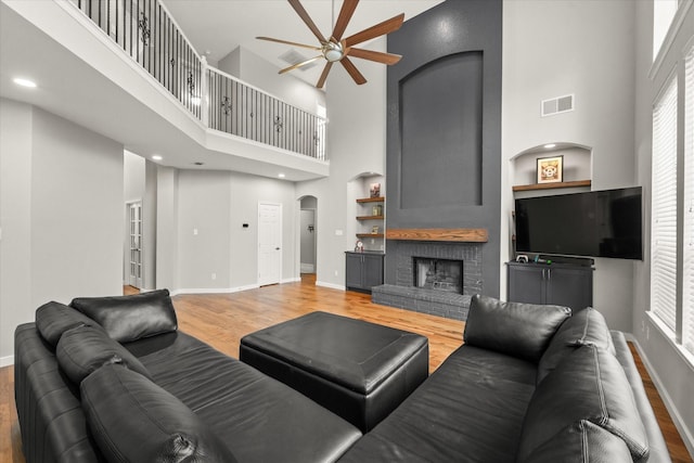 5610 Kensington Ct, Parker, TX 75002 - living room with a high ceiling, a ceiling fan, baseboards, light wood-style floors, and arched walkways