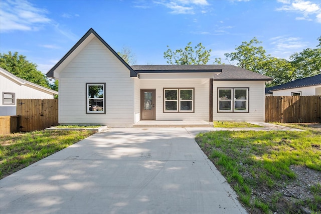 view of front of home featuring fence and roof with shingles