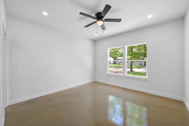 spare room featuring finished concrete flooring, recessed lighting, baseboards, and ceiling fan