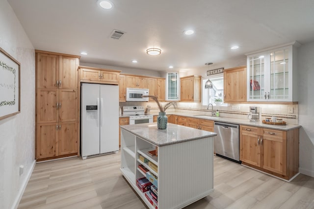 3048 Golfing Green Dr, Farmers Branch, TX 75234 - kitchen featuring white appliances, a sink, light wood-style floors, tasteful backsplash, and a center island