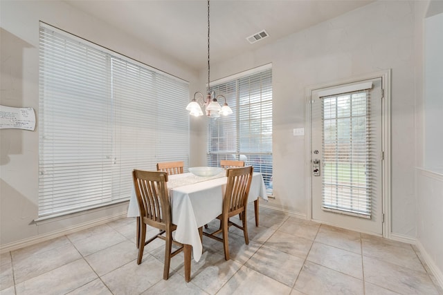 dining room with a chandelier and light tile patterned floors