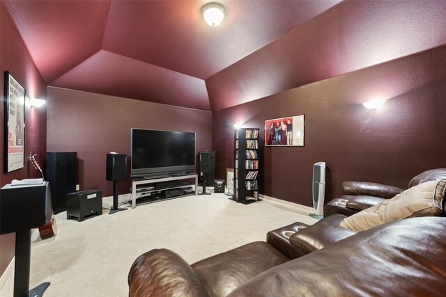 carpeted home theater room with baseboards and lofted ceiling