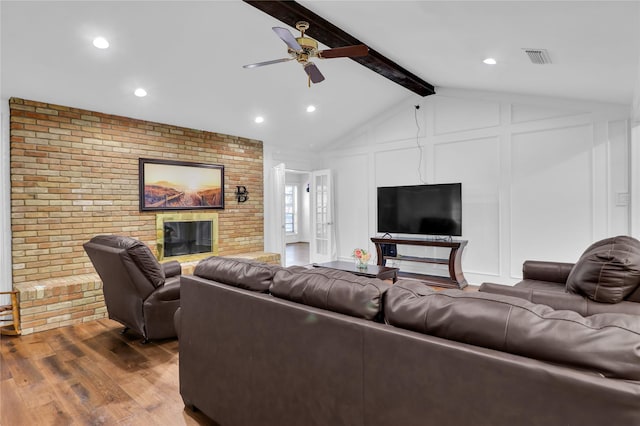 3205 Glasgow Ter, Arlington, TX 76015 - living area with a decorative wall, wood finished floors, a brick fireplace, ceiling fan, and brick wall