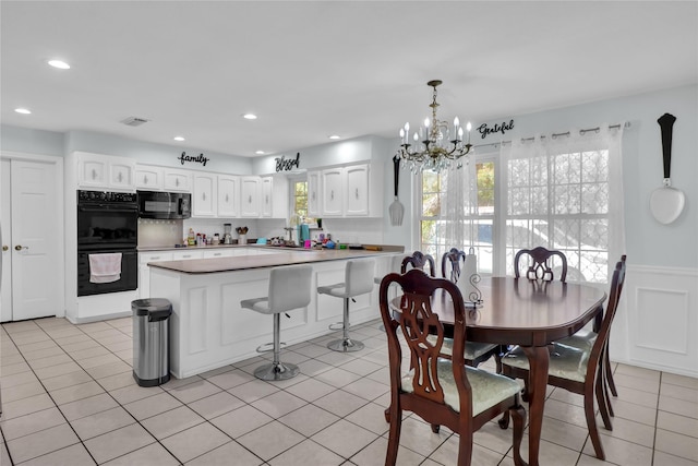 3205 Glasgow Ter, Arlington, TX 76015 - dining room with a chandelier, plenty of natural light, light tile patterned floors, recessed lighting, and a wainscoted wall