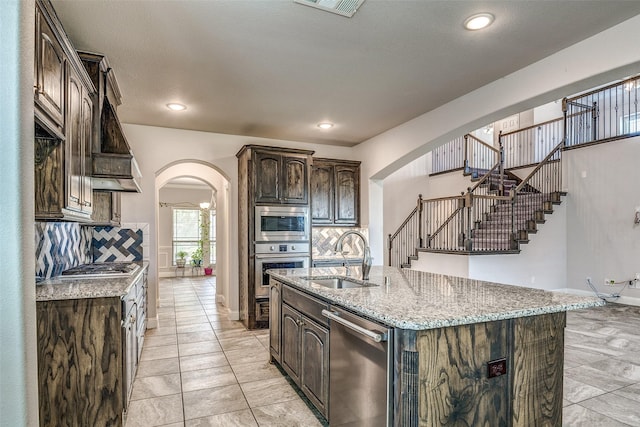 14015 Steadman Dr, Frisco, TX 75035 - kitchen featuring arched walkways, stainless steel appliances, a sink, decorative backsplash, and recessed lighting