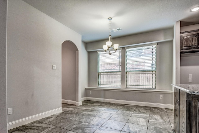 14015 Steadman Dr, Frisco, TX 75035 - unfurnished dining area with arched walkways, baseboards, a chandelier, and a textured wall