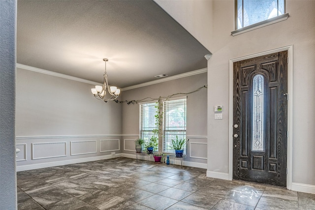 14015 Steadman Dr, Frisco, TX 75035 - entryway featuring healthy amount of natural light, a chandelier, a decorative wall, crown molding, and wainscoting