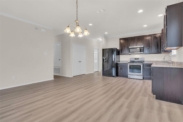 1321 Rivers Creek Ln, Little Elm, TX 75068 - kitchen with stainless steel appliances, ornamental molding, a chandelier, dark brown cabinetry, and light wood-style flooring