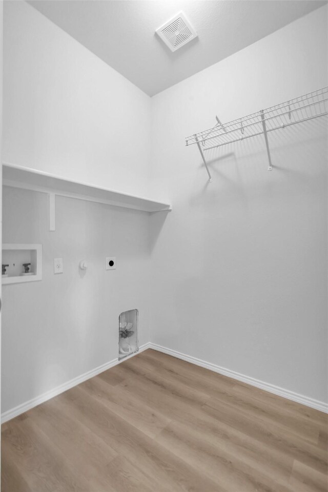 1321 Rivers Creek Ln, Little Elm, TX 75068 - clothes washing area featuring hookup for a washing machine, hookup for an electric dryer, light wood-type flooring, hookup for a gas dryer, and baseboards