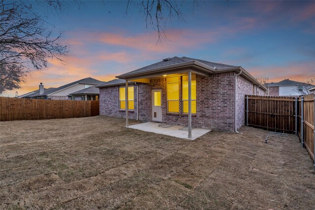1321 Rivers Creek Ln, Little Elm, TX 75068 - back of property at dusk with brick siding and a patio