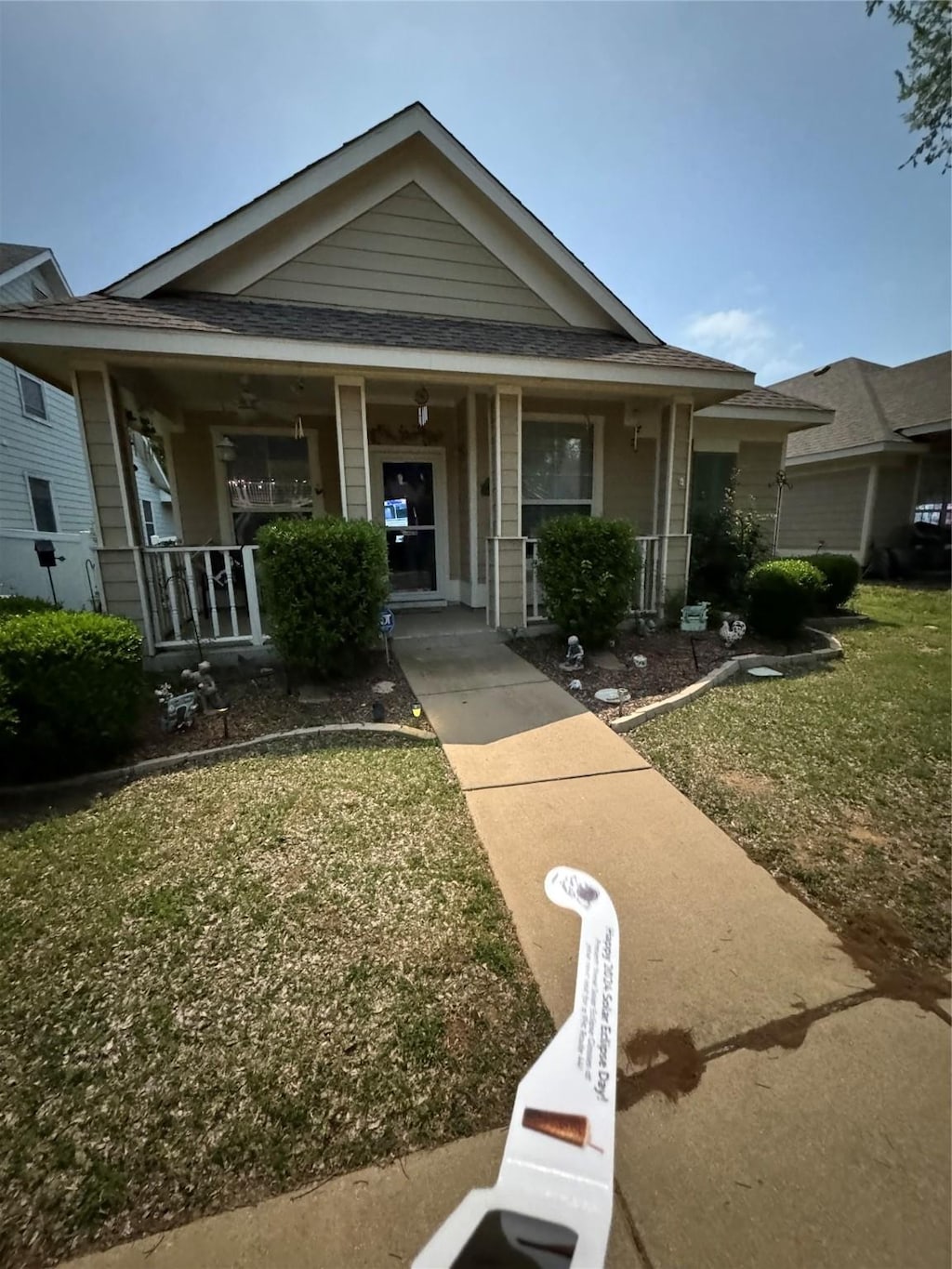 view of front of property with covered porch and a front lawn
