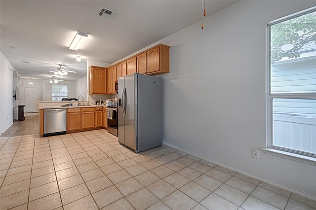 9912 Concord Dr, Providence Village, TX 76227 - kitchen featuring appliances with stainless steel finishes, a peninsula, a sink, a ceiling fan, and light countertops