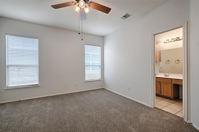9912 Concord Dr, Providence Village, TX 76227 - unfurnished bedroom featuring light colored carpet, a sink, ensuite bath, baseboards, and a ceiling fan