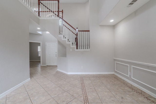 6913 Mccracken Ct, Fort Worth, TX 76132 - empty room with tile patterned flooring, stairway, baseboards, and a towering ceiling