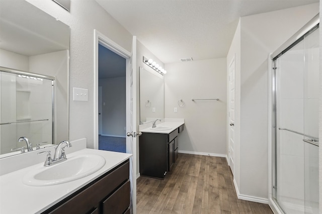 123 Rock Creek Ln, Terrell, TX 75160 - full bathroom featuring a stall shower, wood finished floors, two vanities, and baseboards