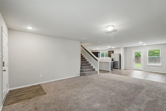123 Rock Creek Ln, Terrell, TX 75160 - unfurnished living room with light colored carpet, recessed lighting, baseboards, and stairs