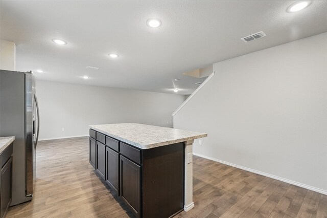 123 Rock Creek Ln, Terrell, TX 75160 - kitchen with freestanding refrigerator, light countertops, light wood-style flooring, a center island, and baseboards
