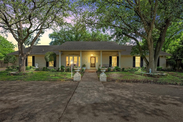 single story home with brick siding and a porch