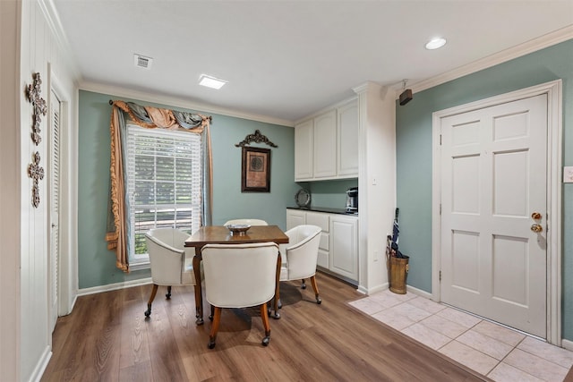 dining area featuring light wood finished floors, crown molding, baseboards, and recessed lighting