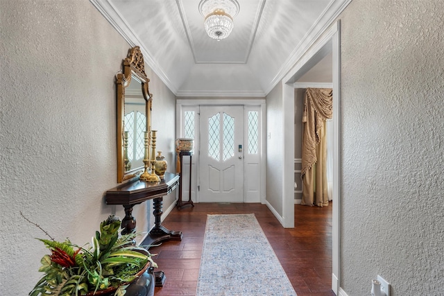 entrance foyer featuring a textured wall, wood finished floors, and ornamental molding