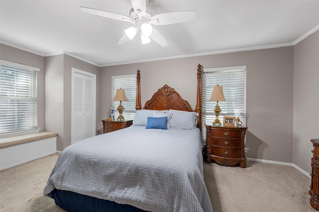 bedroom with carpet floors, a closet, baseboards, crown molding, and ceiling fan