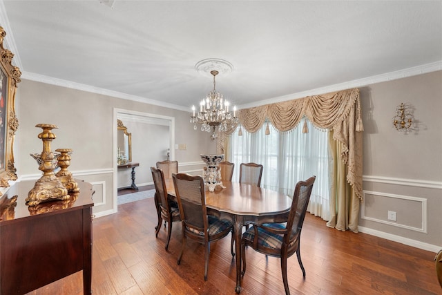 dining space with a chandelier, wood finished floors, ornamental molding, and baseboards