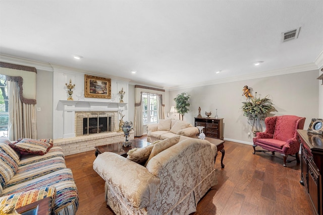 living area with crown molding, wood finished floors, a brick fireplace, baseboards, and recessed lighting
