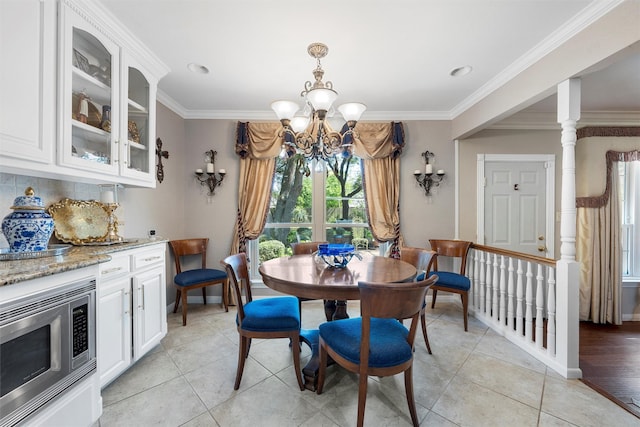 dining area with plenty of natural light, a chandelier, light tile patterned flooring, crown molding, and baseboards