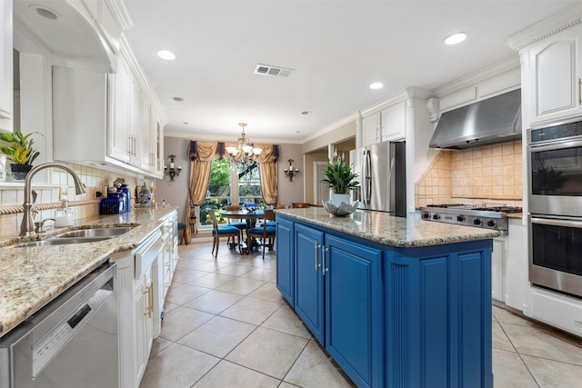 kitchen featuring appliances with stainless steel finishes, blue cabinets, ventilation hood, a sink, and a center island