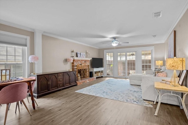 5036 Lake Shore Dr, Waco, TX 76710 - living room with light wood finished floors, ceiling fan, crown molding, and a brick fireplace