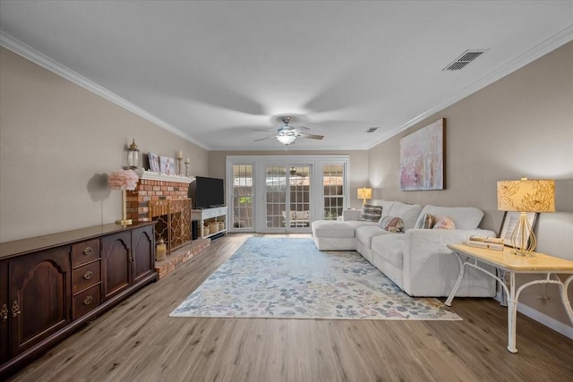 5036 Lake Shore Dr, Waco, TX 76710 - living area featuring wood finished floors, crown molding, a brick fireplace, a ceiling fan, and baseboards