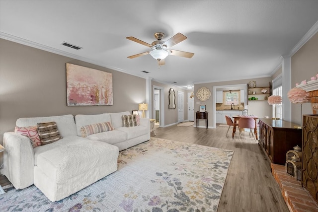 5036 Lake Shore Dr, Waco, TX 76710 - living room with ornamental molding, wood finished floors, ceiling fan, and baseboards