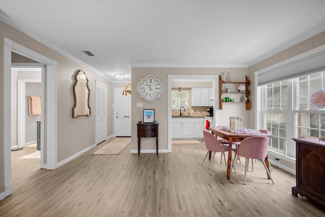 5036 Lake Shore Dr, Waco, TX 76710 - dining space with light wood finished floors, crown molding, and baseboards